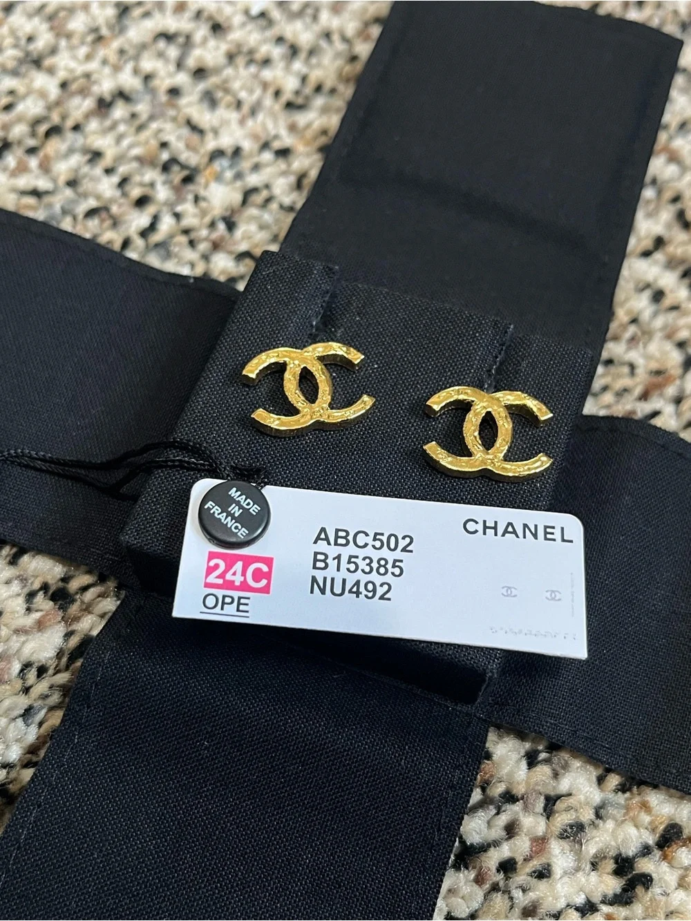 CHANEL Gold Interlocking CC Stud Earrings on Black